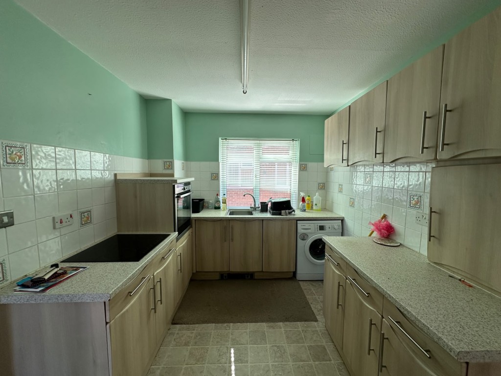 Lot: 6 - BALCONY FLAT OVERLOOKING DEVONSHIRE PARK TENNIS COURTS - Flat kitchen with cupboards and part tiled walls